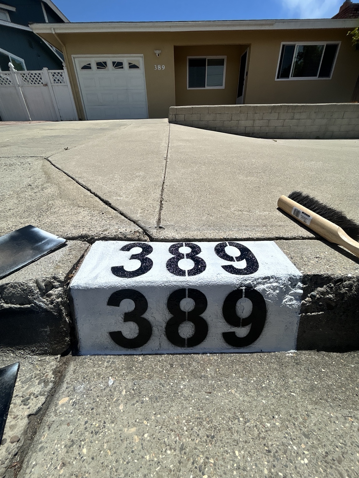 Address 389 painted on both the front and top of a curb